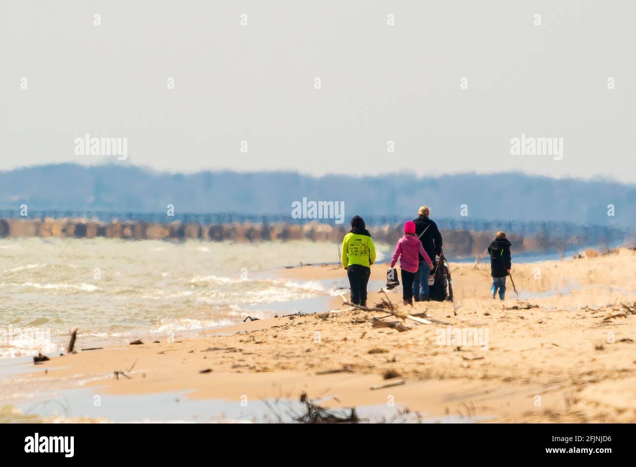 Two young mothers walking with their children along the beach on a cold spring afternoon. Part of the Two Rivers segment of the national Ice age Trail Stock Photo
