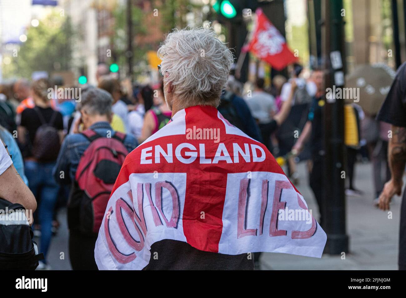 April 24, 2021, London, England, United Kingdom: Man carries St George's flag with ' Covid lies' written on it during an anti-lockdown 'Unite for Free Stock Photo