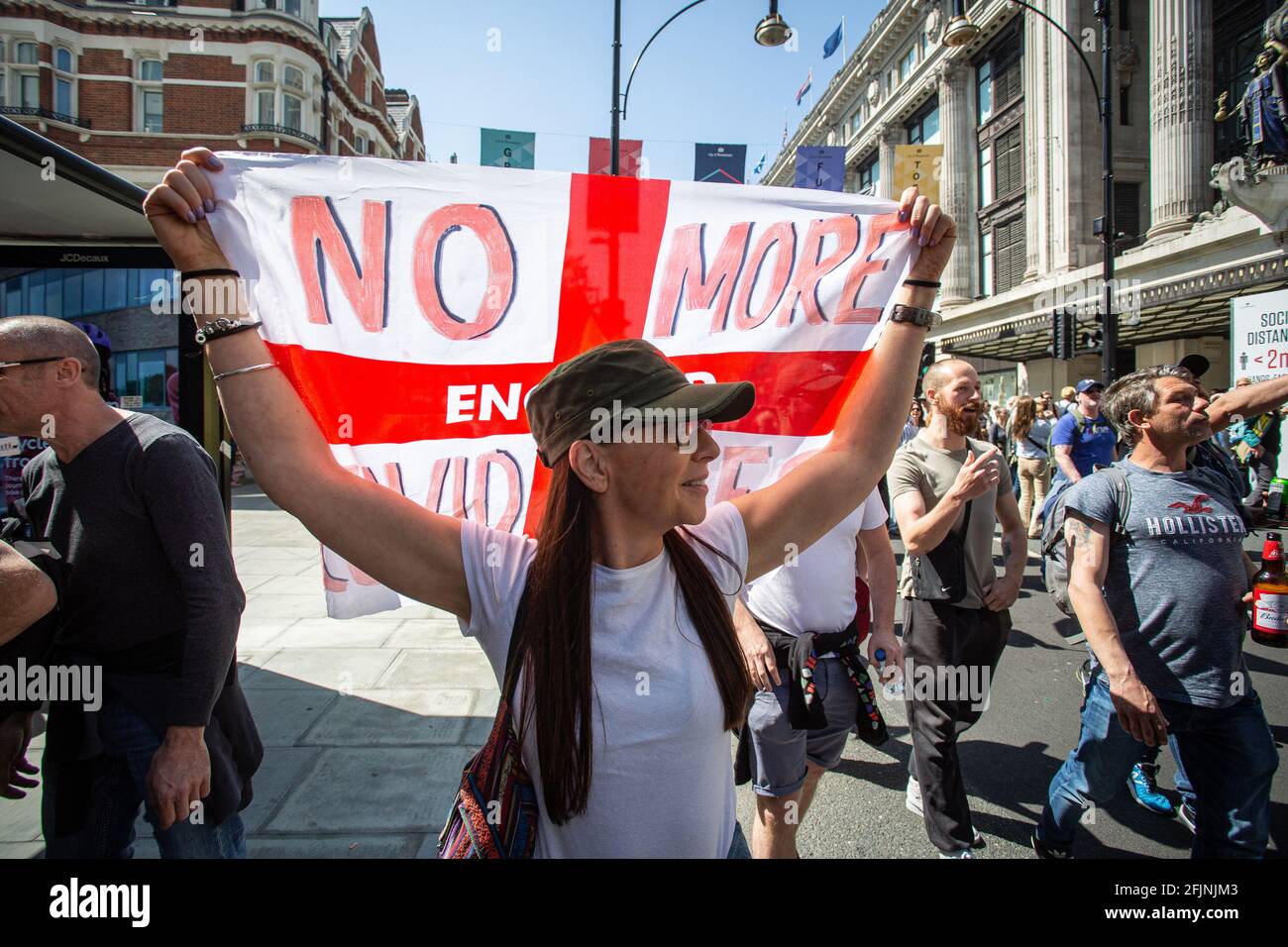 April 24, 2021, London, England, United Kingdom: Woman carries St George's flag with 'No more Covid lies' written on it during an anti-lockdown 'Unite Stock Photo