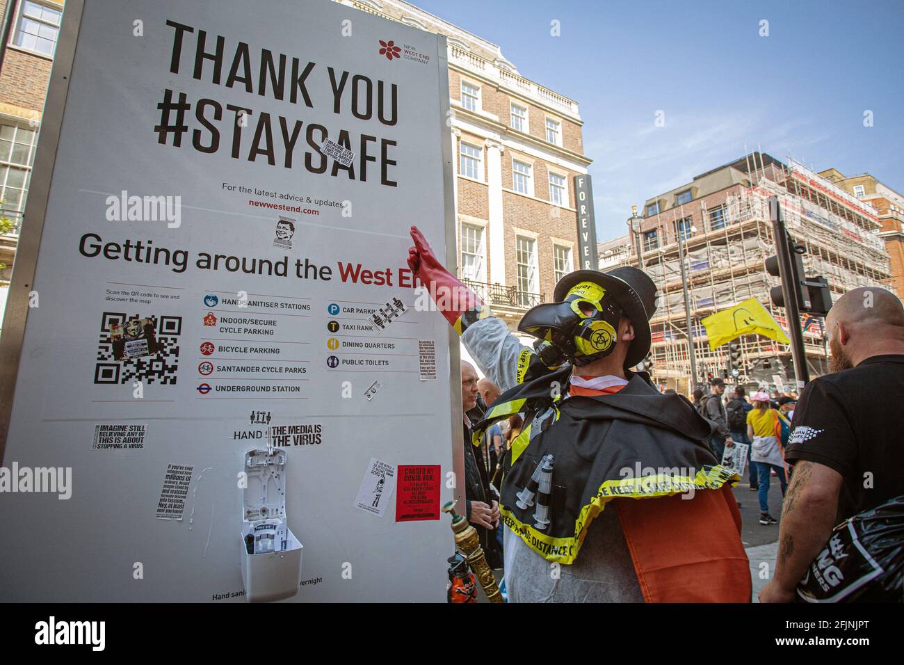 April 24, 2021, London, England, United Kingdom: A man wearing a costume with plague mask pointing to Stay Save sign, as he takes part in an anti-lock Stock Photo