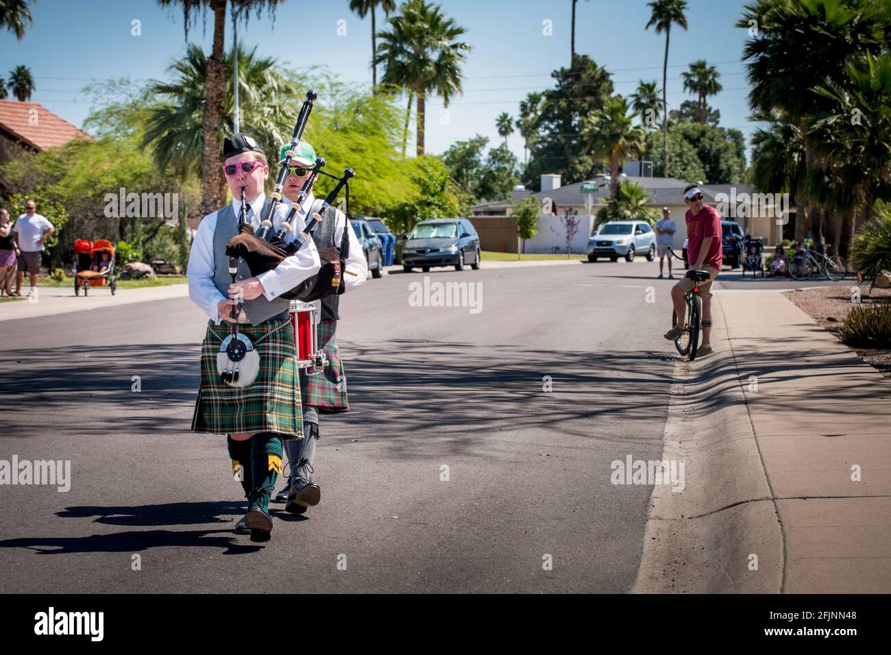 Arizona, USA. 24th Apr, 2020. The 2-man Pipe Band Thomas Rowley, 15, bag pipes and Jaymes, 16, drummer, performed on neighberhood streets in Tempe, Ariz., in the early days of the lockdown. Said Thomas, ''The 2 Man Pipe Band started as a way to entertain our neighbors on St Patrick's Day. It then turned into performing around Tempe to entertain people during quarantine. We figured we could make some people happy, as opposed to just sitting around the house all day. We were busy! When the weather got too hot, and we had to stop performing, we better understood why people were so excited to see Stock Photo