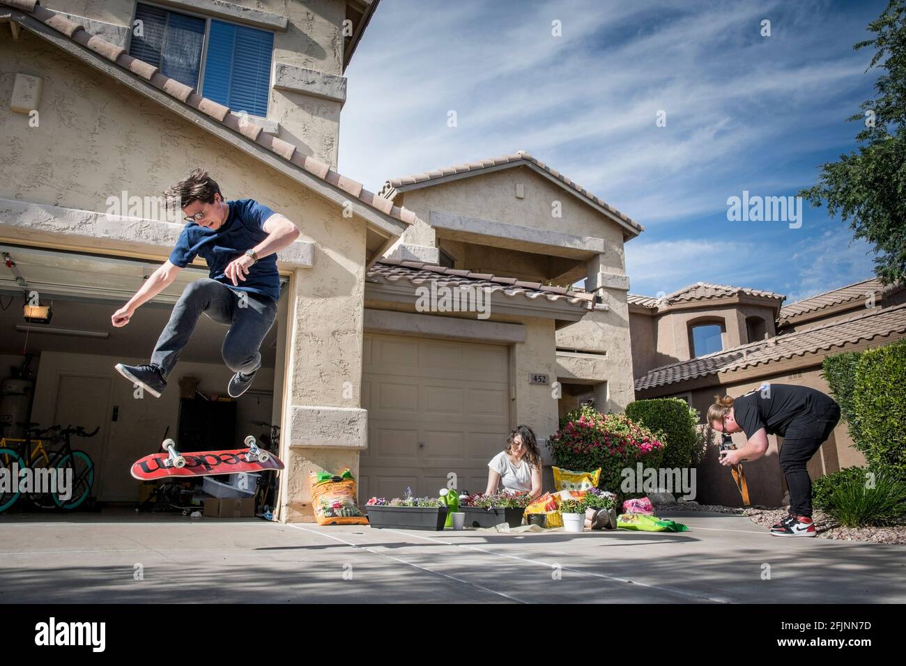 Arizona, USA. 17th Apr, 2020. David Glosser, skater, Kiyomi Kawana-Glosser and Ausin Gavin, entertain themselves in front of their shred home in Gilbert Arizona during the COVID lockdown in May of 2020. Credit: Rick D'Elia/ZUMA Wire/Alamy Live News Stock Photo