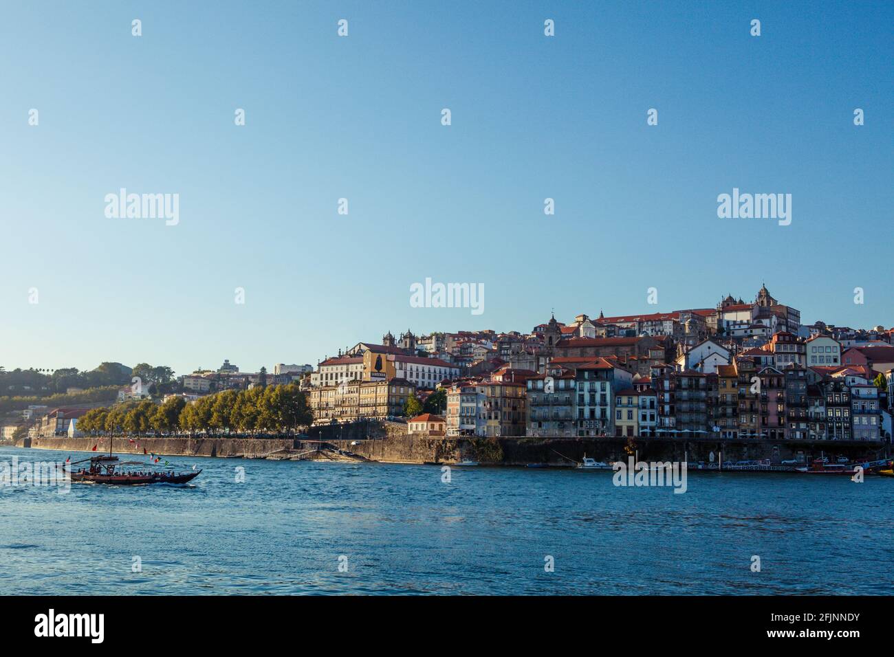 A barge sailing in the summery evening on the Douro River in Porto, Portugal. Stock Photo