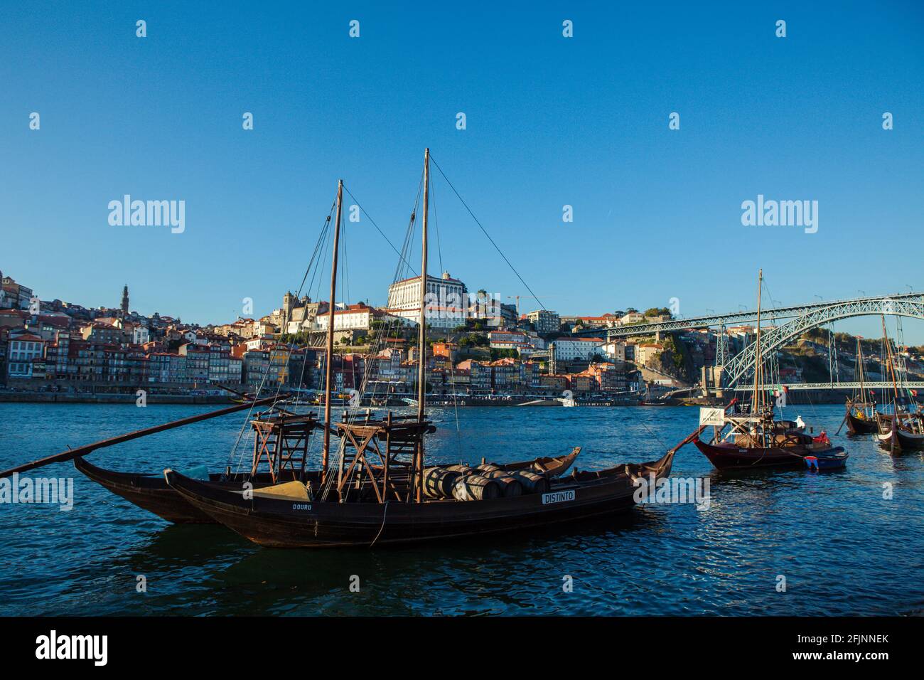 Barges on the river Douro in Porto, with the Dom Luis bridge in the background, Portugal. Stock Photo