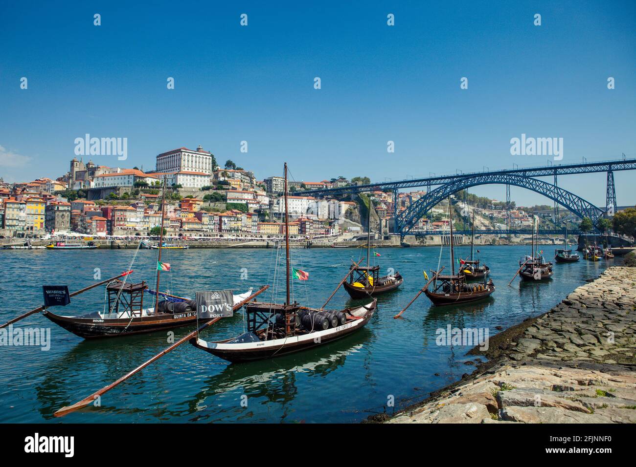 Barges on the river Douro in the historical city of Porto, with the iconic Dom Luis bridge in the background. Stock Photo