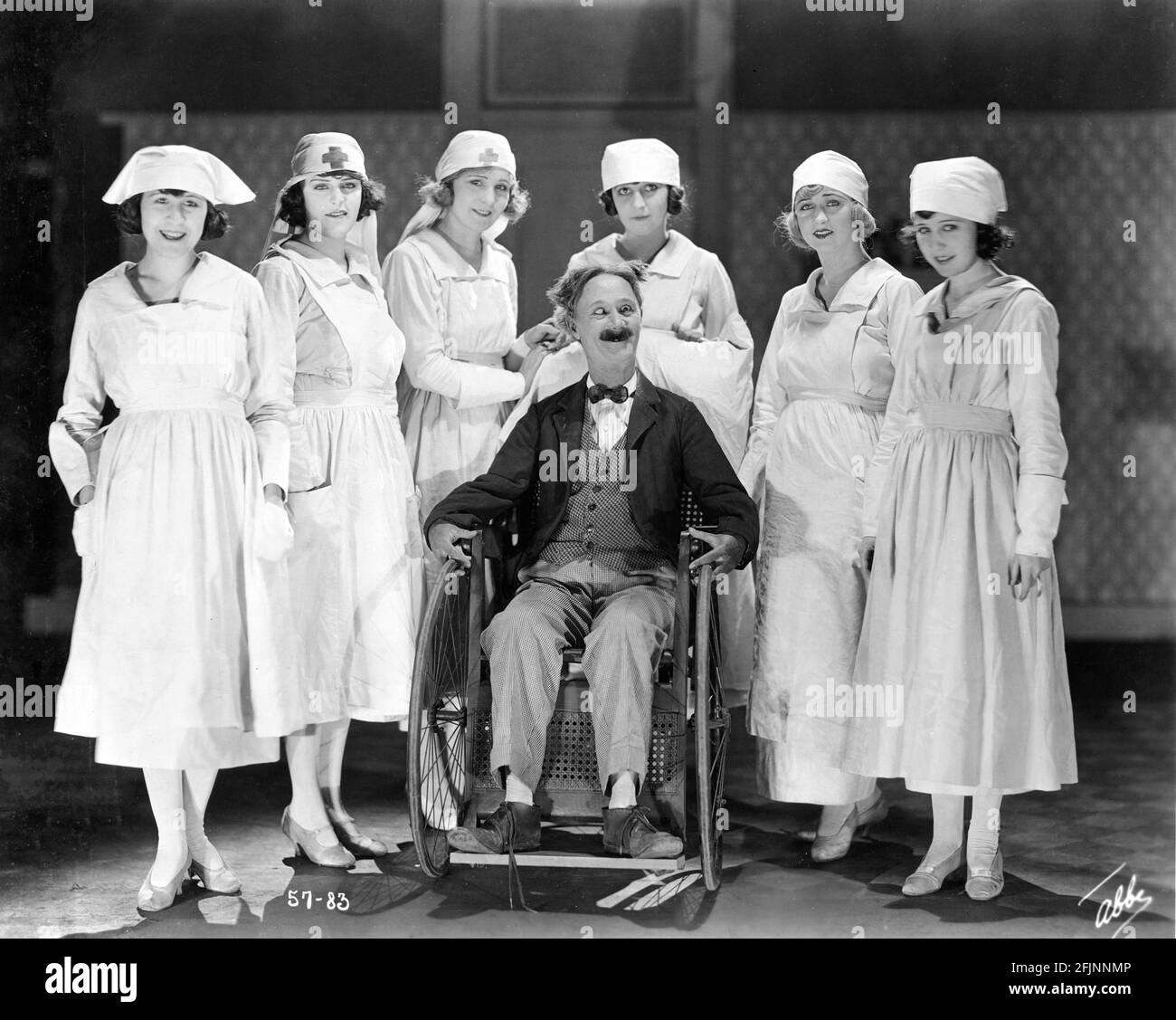 Cross-Eyed Comedian BEN TURPIN surrounded by MACK SENNETT BATHING BEAUTIES JANE ALLEN VIRGINIA FOX PHYLLIS HAVER KATHRYN McGUIRE THELMA HILL and THELMA BATES dressed as Nurses on set portrait by JAMES ABBE for the silent comedy short MARRIED LIFE 1920 director ERLE C. KENTON Mack Sennett Comedies / Associated First National Pictures Stock Photo