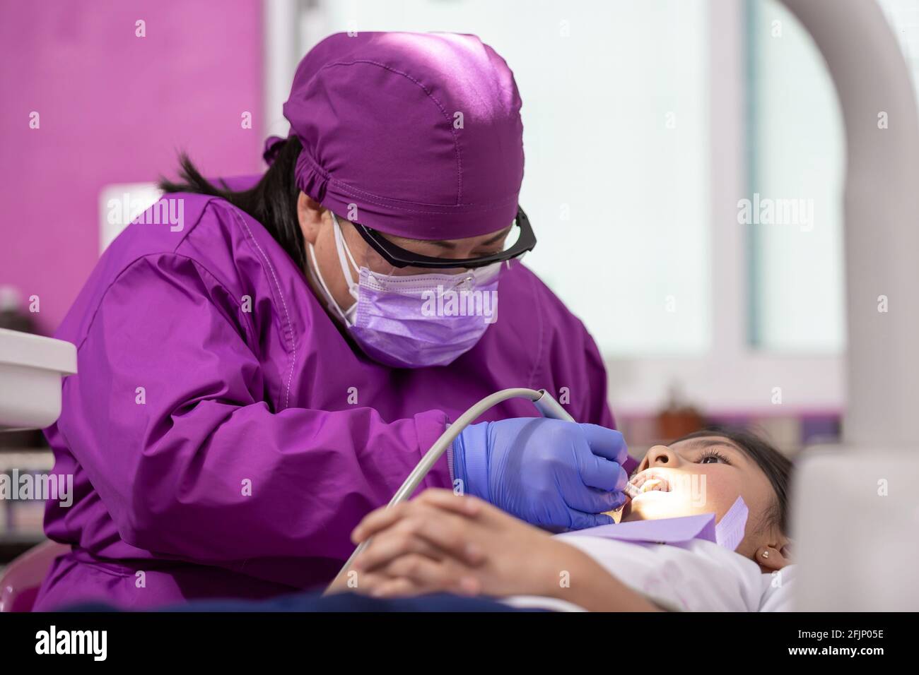 A closeup of a Mexican female dentist doing dental treatment on the