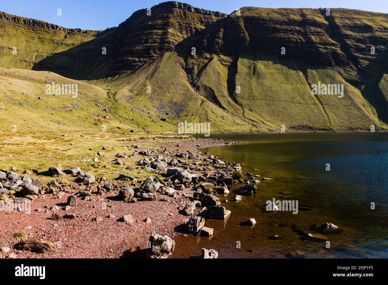 A small lake at the foot of mountains in the Brecon Beacons (Llyn y Fan Fach, Wales, UK) Stock Photo