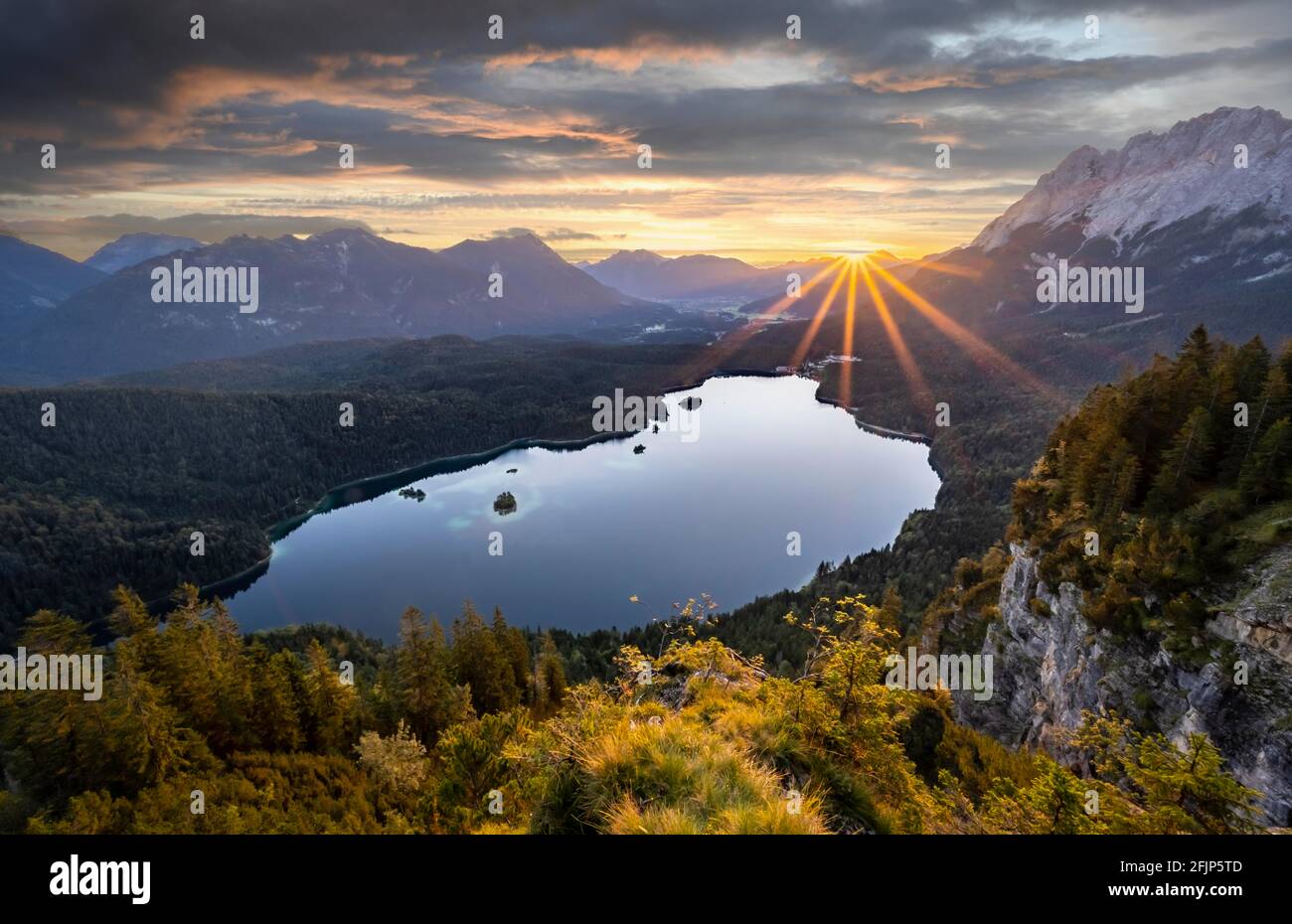 Eibsee lake at sunrise, sun shining over Bavarian alpine foothills, right Zugspitze, Wetterstein mountains near Grainau, Upper Bavaria, Bavaria Stock Photo