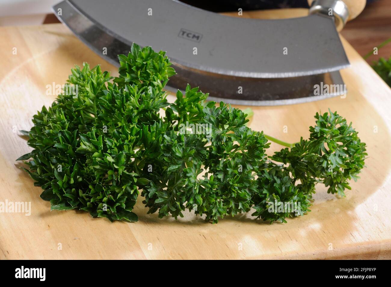 Parsley (Petroselinum crispum) on a weighing board, chopping knife