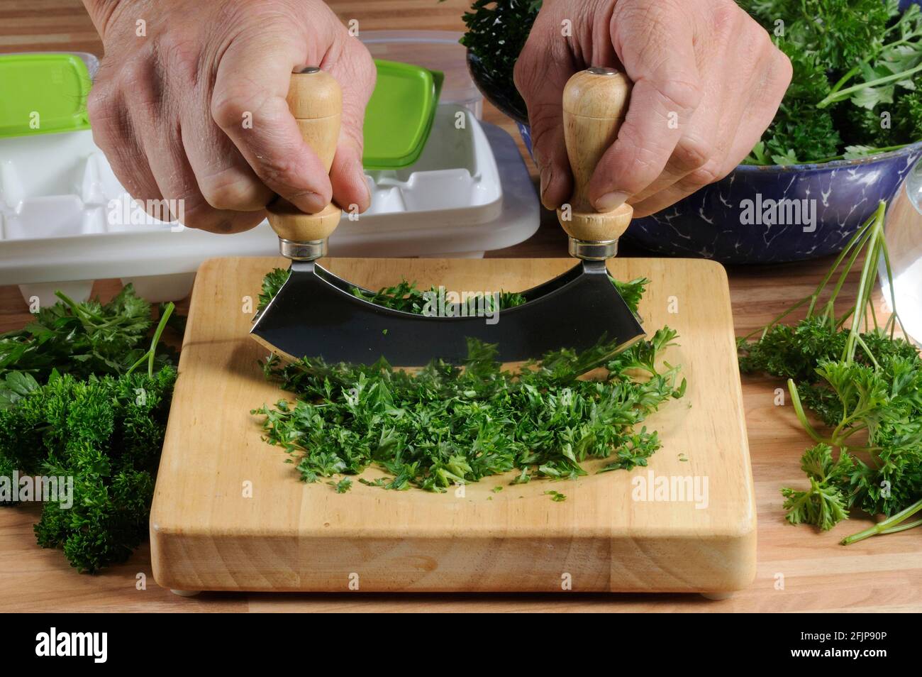 Parsley (Petroselinum crispum) on a weighing board, chopping knife