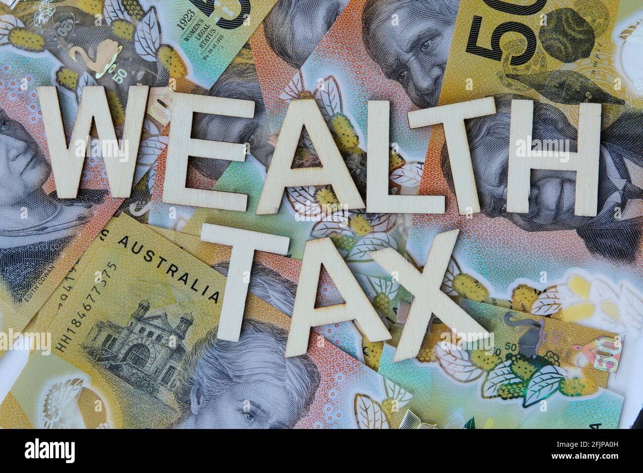 Wealth tax signage on a background of Australian dollars. Stock Photo