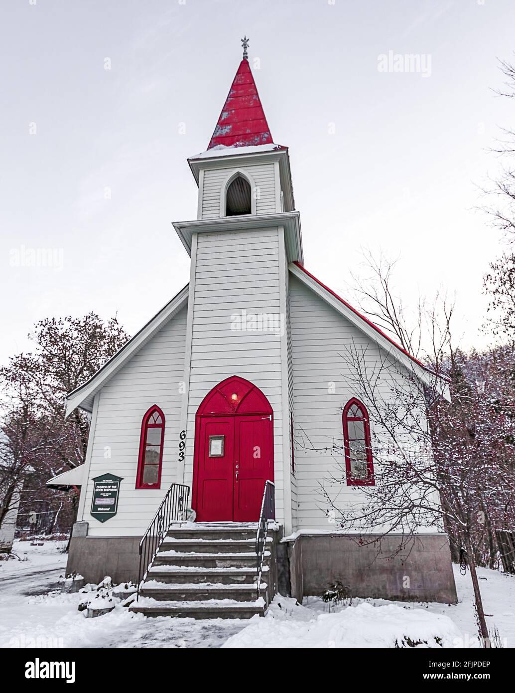 Small white country church with red doors and a red steeple Stock Photo