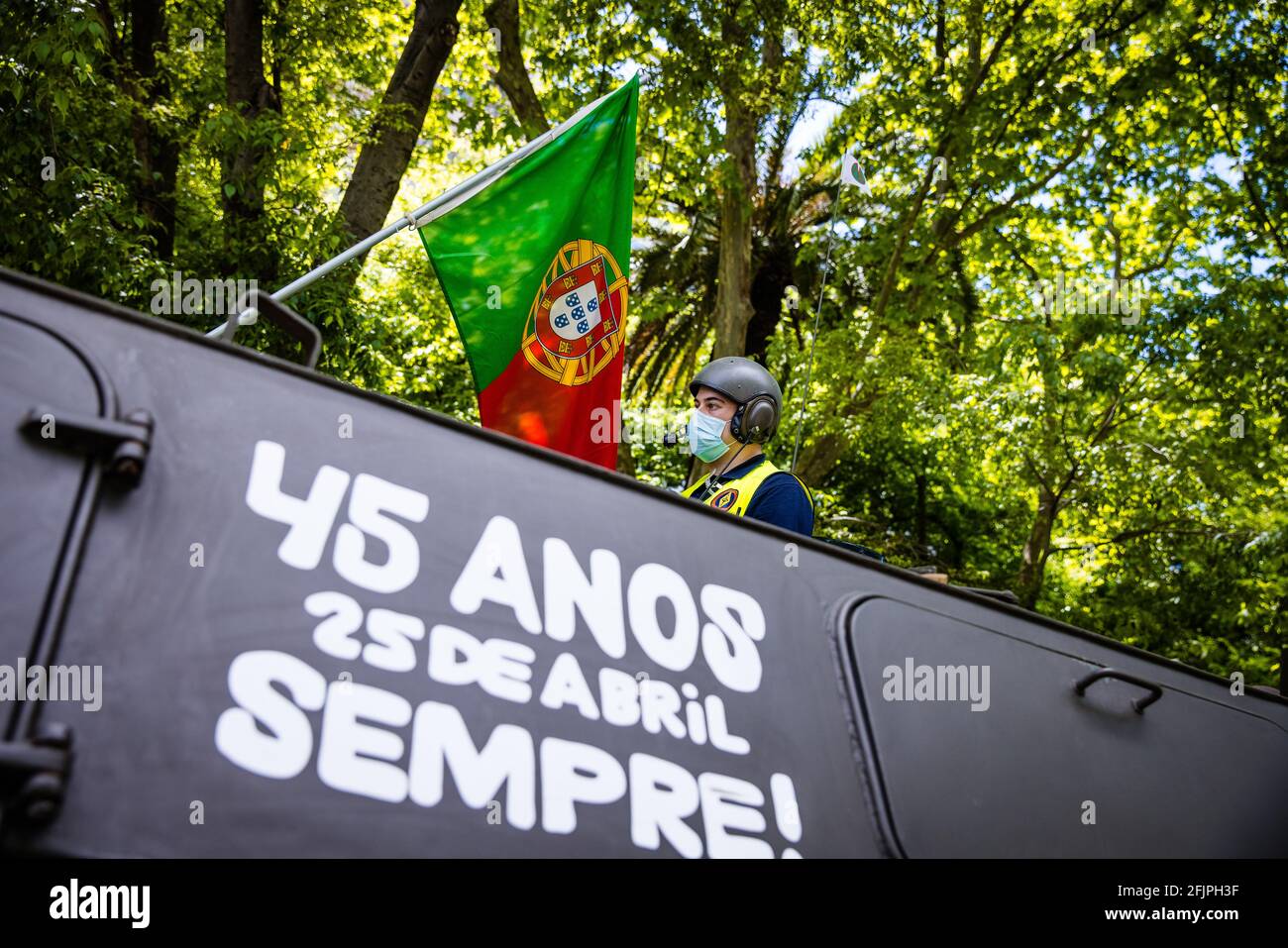 Lisbon, Portugal. 25th Apr, 2021. A military personnel wearing a facemask as a preventive measure against the spread of covid-19 attached a Portuguese flag, leads the old Chaimite during the anniversary.1 year after the start of the pandemic, the Portuguese government authorized the celebration of the 47th anniversary of Revolution of 25 April, also known as the Carnation Revolution. Credit: SOPA Images Limited/Alamy Live News Stock Photo