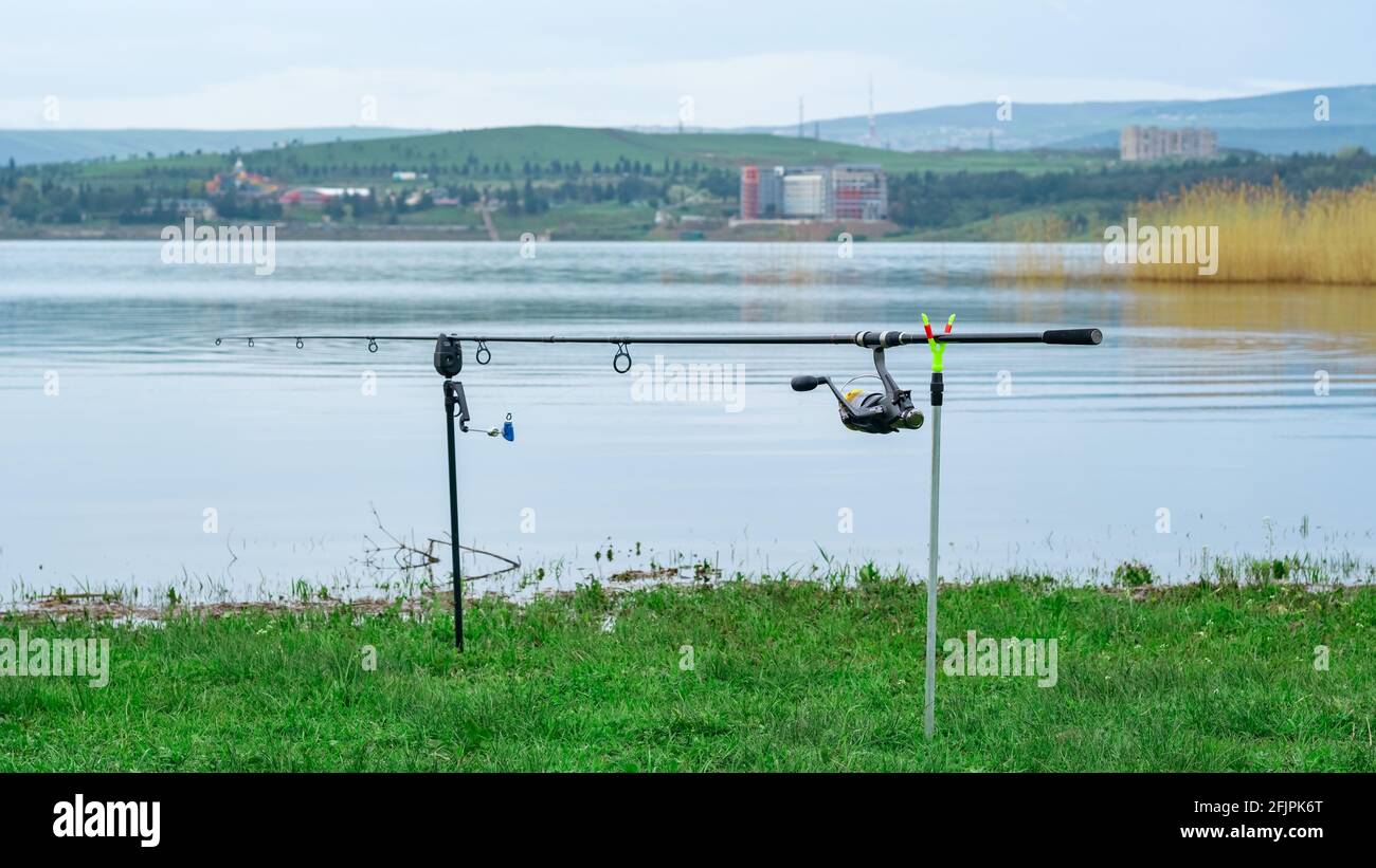 Fishing adventures, carp fishing. Fisherman with green rubber thigh high  boots for fishing and camouflage shirt Stock Photo - Alamy