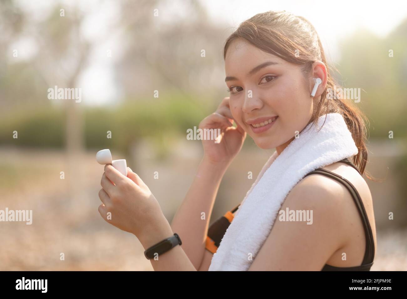 Photo of a beautiful asian young fitness woman running outdoors listening music with earphones Stock Photo