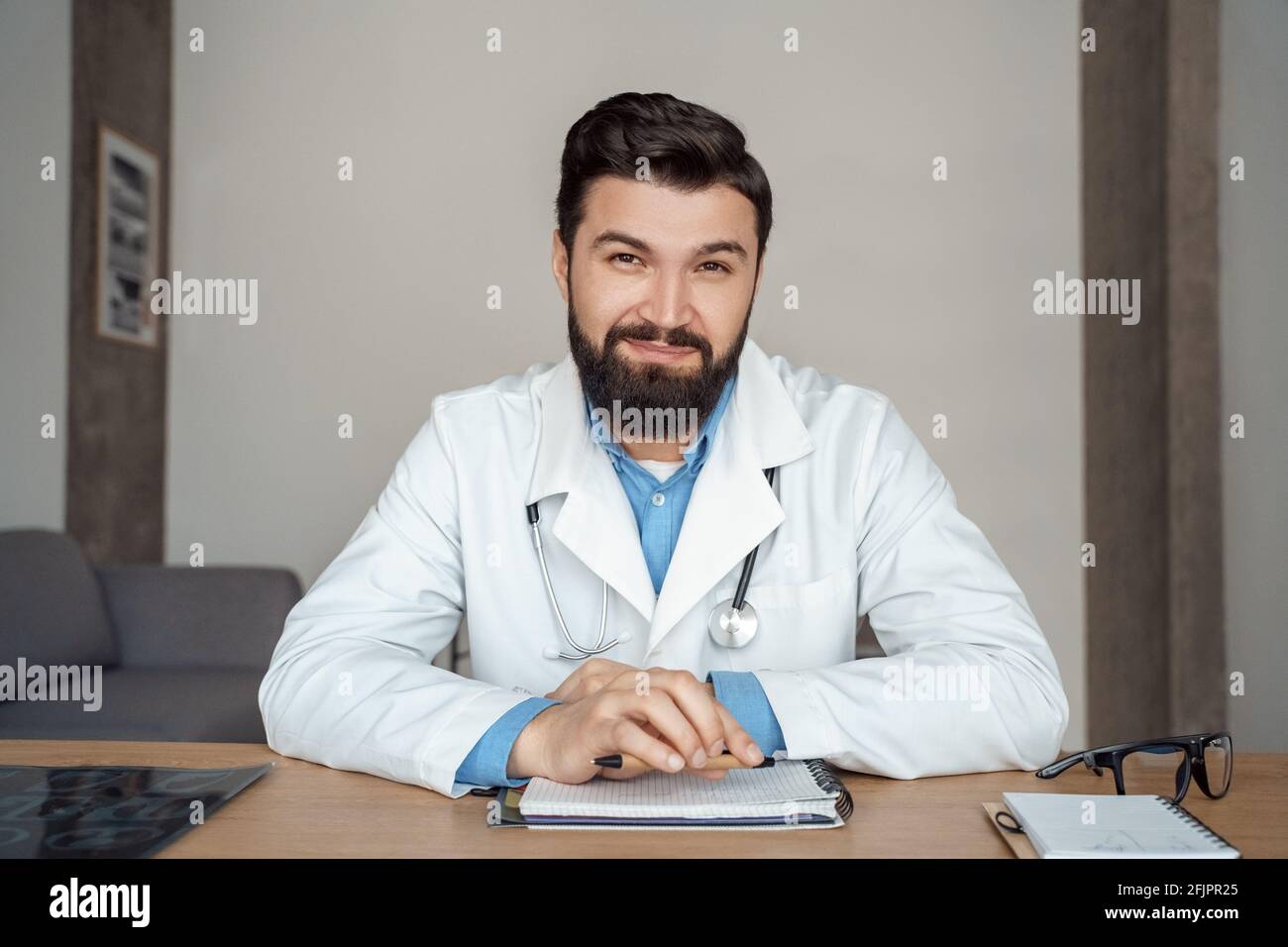 Headshot portrait of positive male caucasian doctor in white uniform at ...