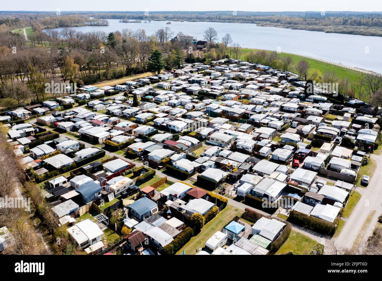 Friesoythe, Germany. 23rd Apr, 2021. Numerous caravans of permanent campers  are parked at the Wilken family's campsite at the Thülsfelder Talsperre in  the district of Cloppenburg (aerial view with drone). The demand