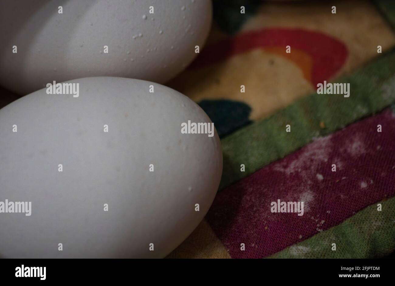 two whole white eggs set out on a quilted place mat Stock Photo