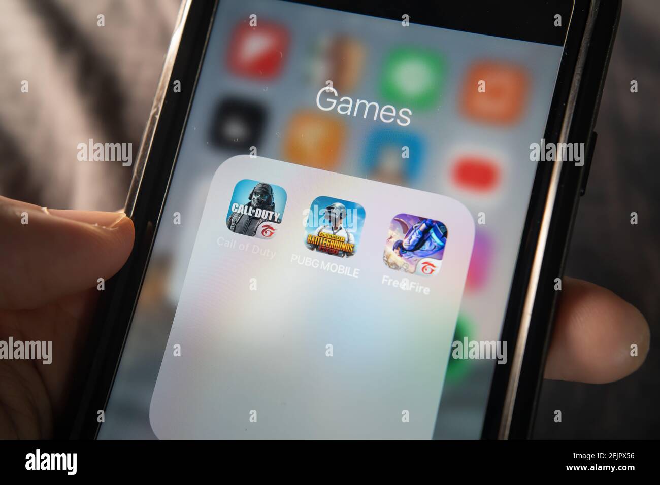 Bangkok, Thailand - April 17, 2021 : iPhone 7 showing its screen with popular shooting games which are Call of Duty mobile, PUBG mobile and Free Fire. Stock Photo