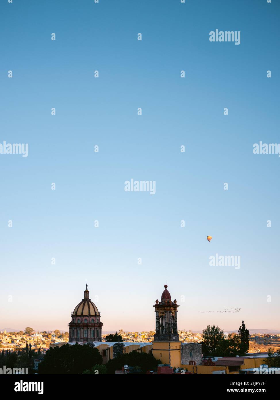 Hot air balloons above the city of San Miguel de Allende, Mexico around sunrise. Colorful travel photography image. Stock Photo