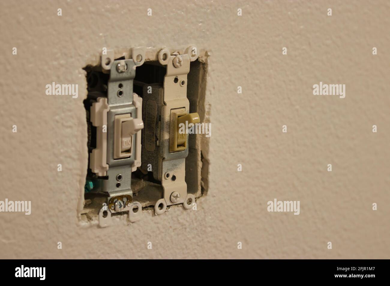 uncovered light switches in a white wall Stock Photo