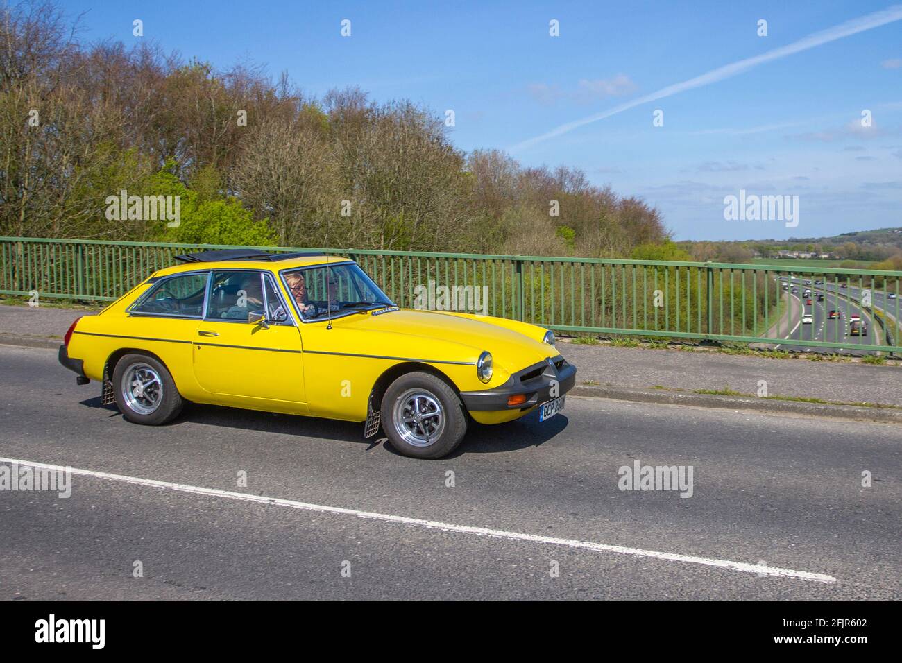 1980 yellow 80s MG B GT moving vehicles, cars, vehicle driving,  UK roads, motors, motoring,  road network Stock Photo