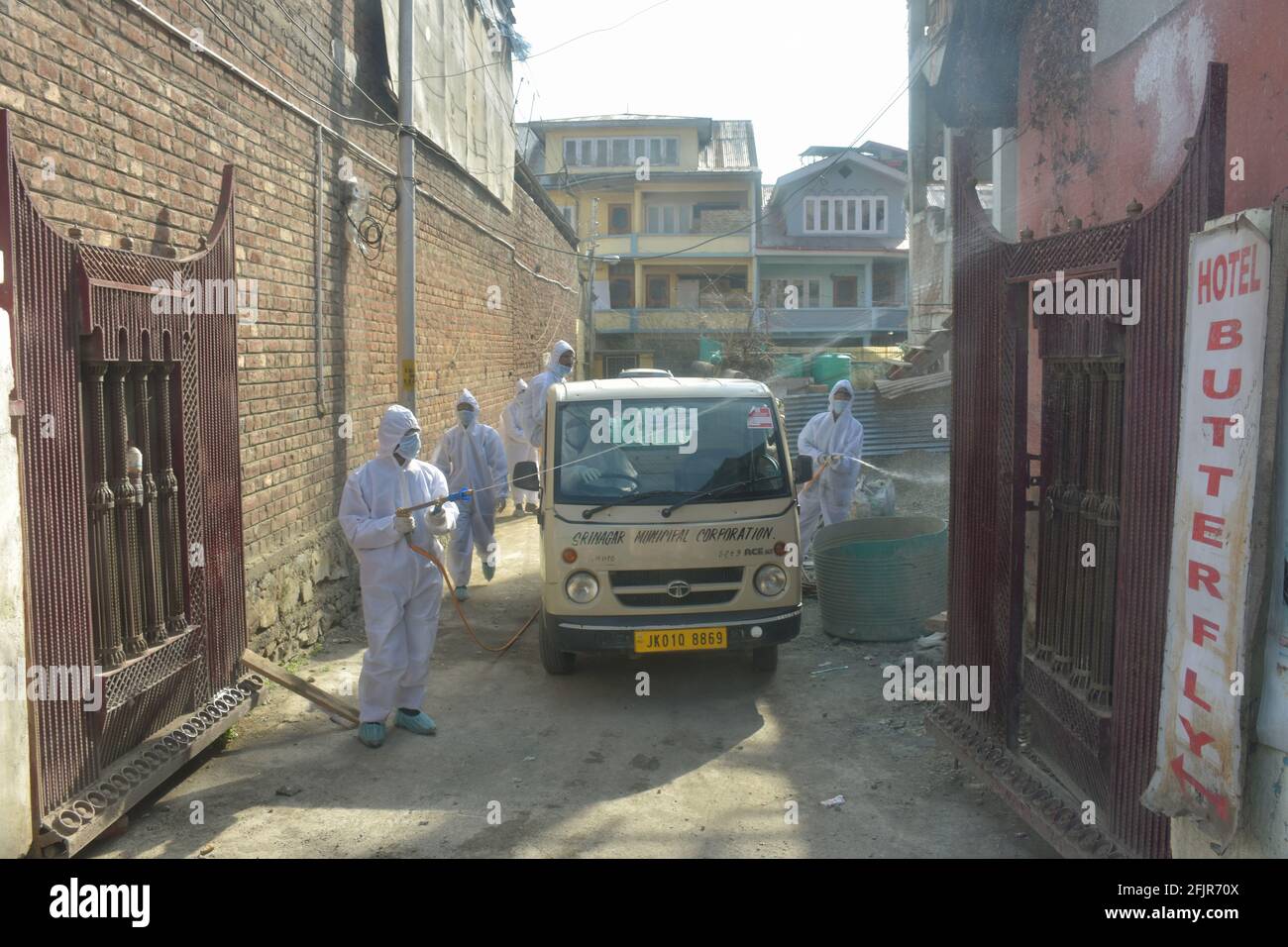 Srinagar, Jammu and kashmir India 07 August 2020. Vehicles small and big sanitizing towns and streets during coronavirus lockdown. Men dressed kits ar Stock Photo