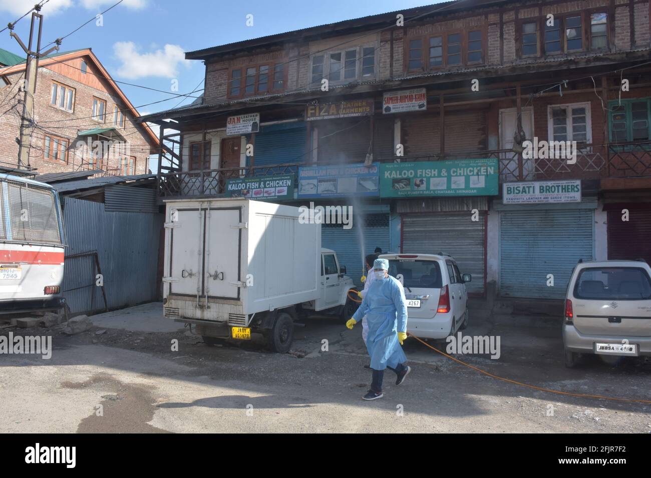 Srinagar, Jammu and kashmir India 07 August 2020. Vehicles small and big sanitizing towns and streets during coronavirus lockdown. Men dressed kits ar Stock Photo
