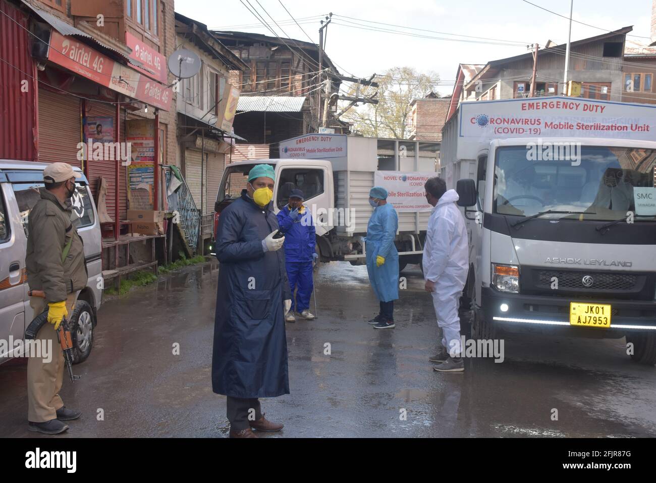 Srinagar, Jammu and kashmir India 07 August 2020. Vehicles small and big sanitizing towns and streets during coronavirus lockdown. Men dressed kits ar Stock Photo