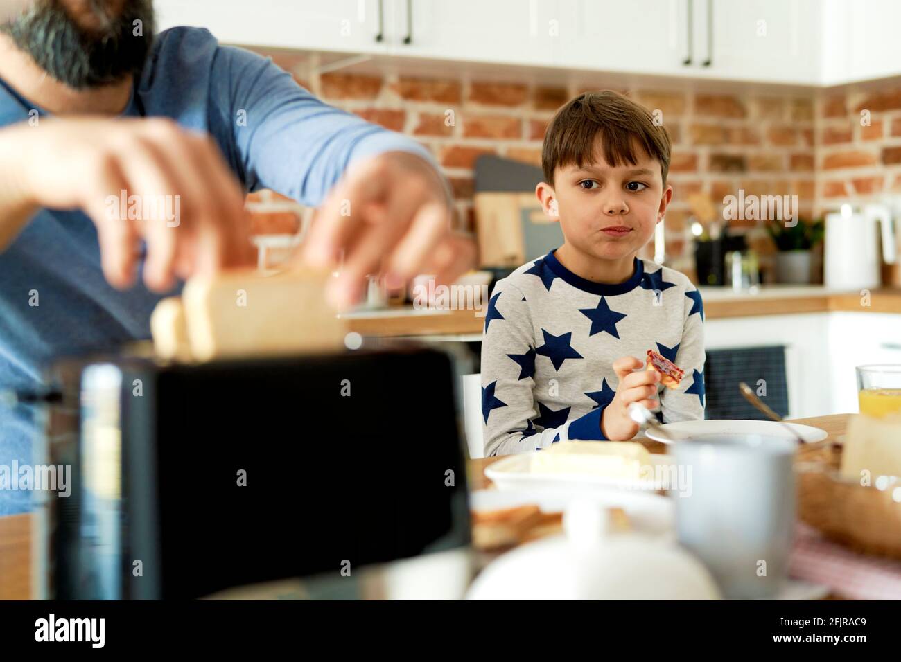 Close up of father and son eating breakfast in the kitchen Stock Photo