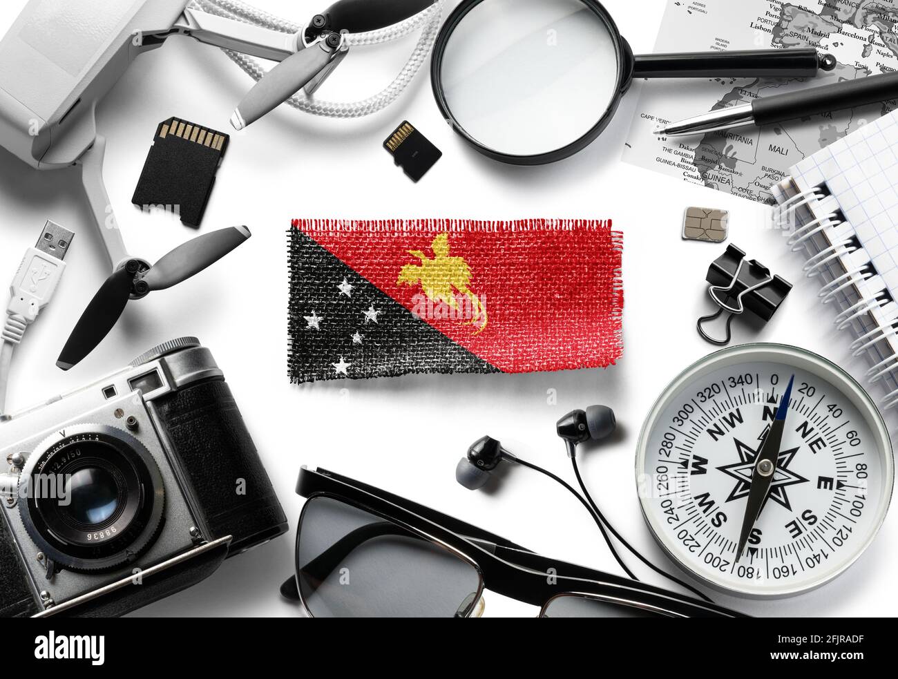 Flag of Papua New Guinea and travel accessories on a white background. Stock Photo