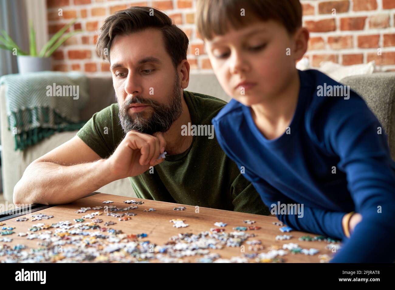 Close up of father and son solving jigsaw puzzle Stock Photo