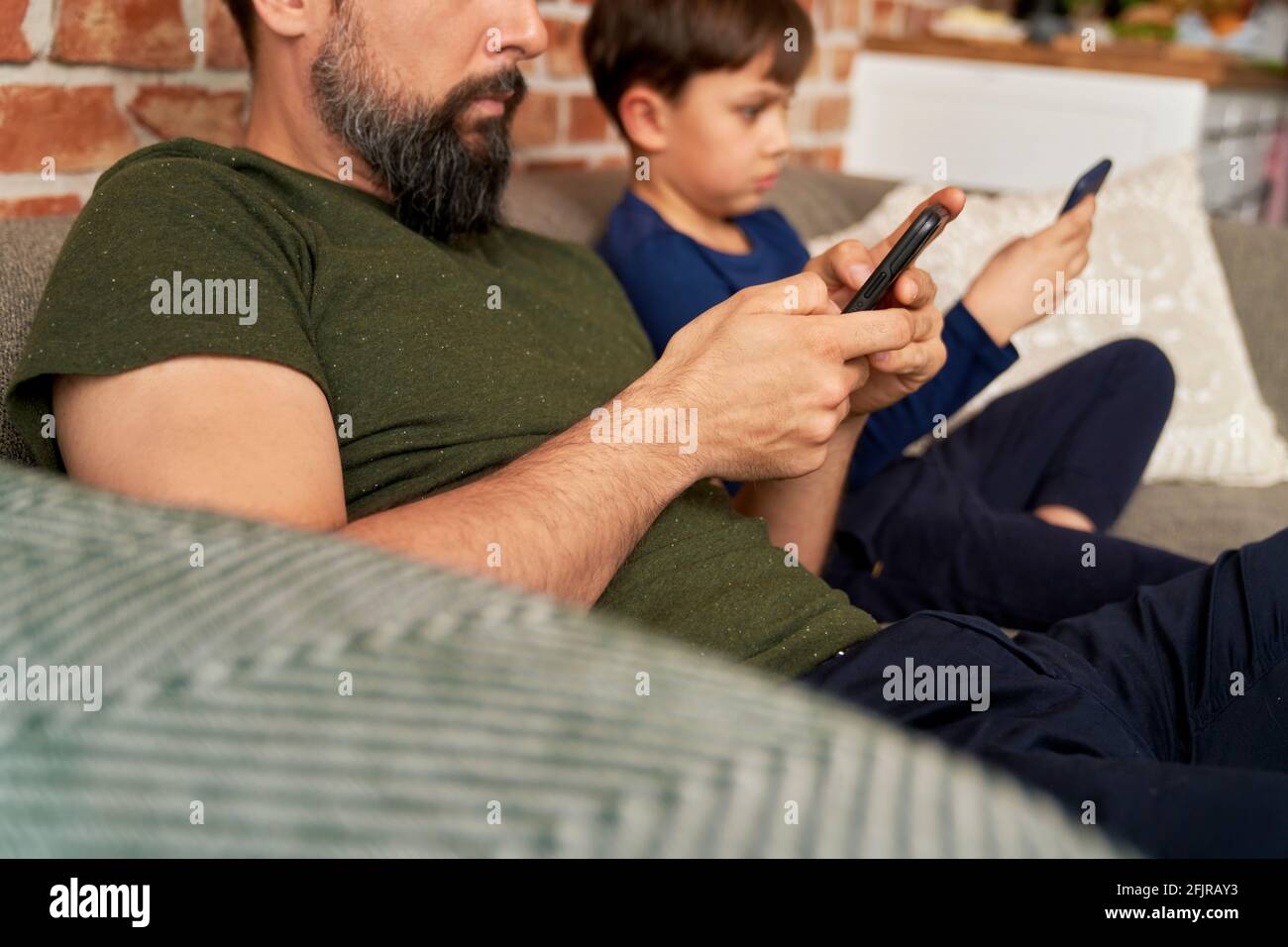 Close up side view of father and son using mobile phone Stock Photo