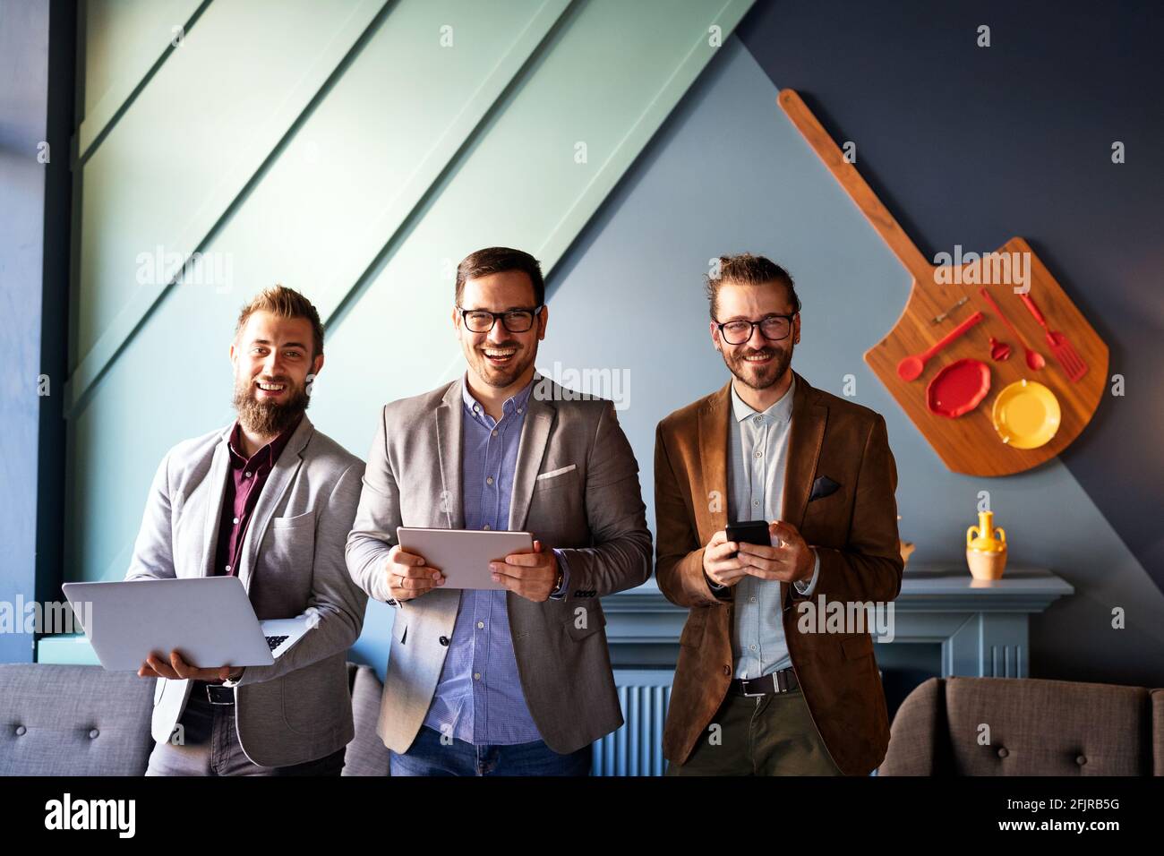 Sharing fresh ideas. Group of young business people in smart casual wear talking and smiling Stock Photo
