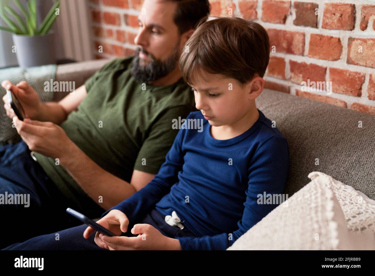 Close up of father and son using mobile phone Stock Photo