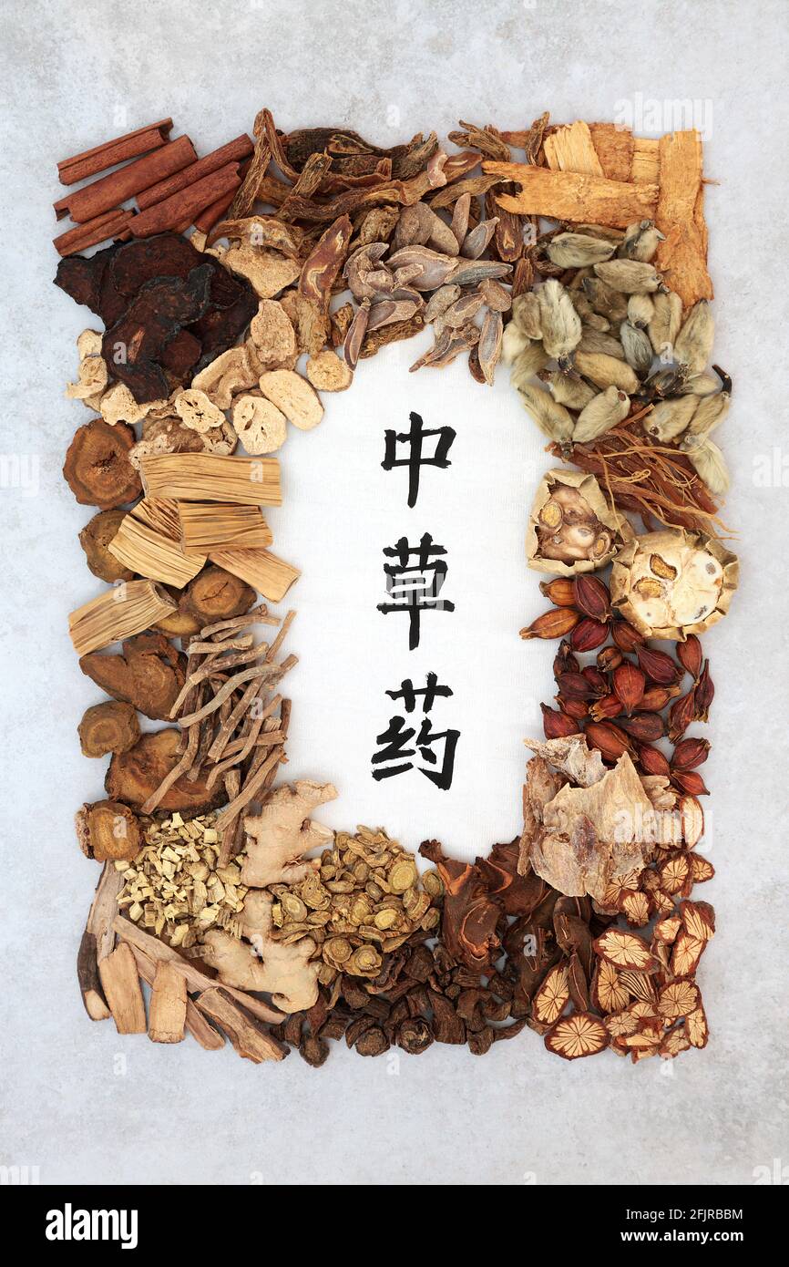 Chinese healing herb collection used in traditional herbal medicine with calligraphy script on rice paper Translation reads as chinese healing herbs. Stock Photo