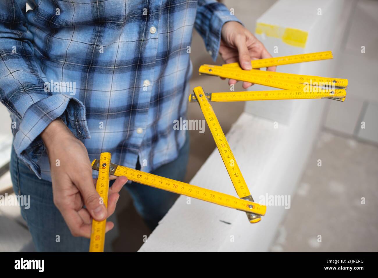 pretty young worker woman with blue work shirt working on construction ...