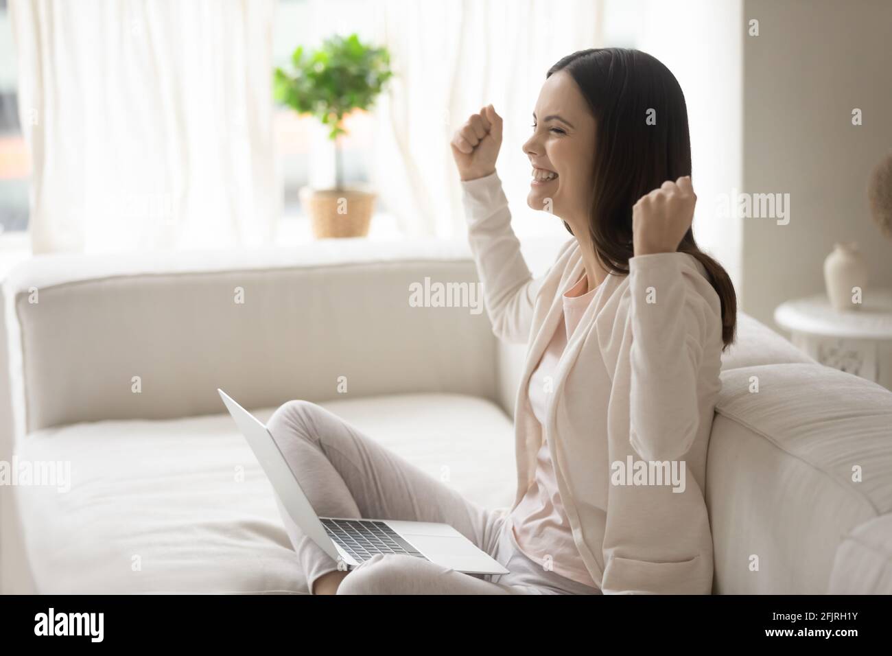 Happy excited millennial woman with laptop getting good news Stock Photo