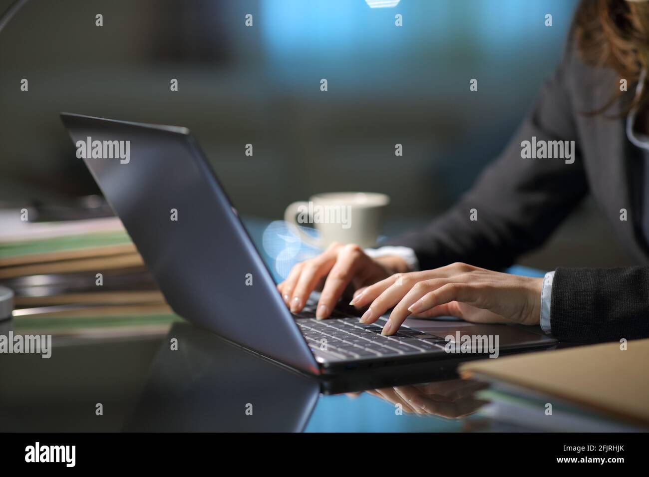 Close up of a tele worker hands typing on laptop in the night at homeoffice Stock Photo