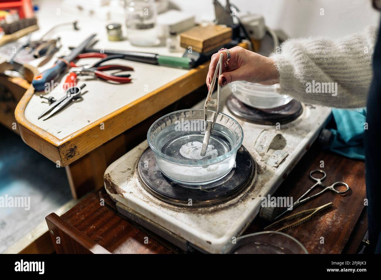Faceless craftswoman working in jewelry workshop. Stock Photo