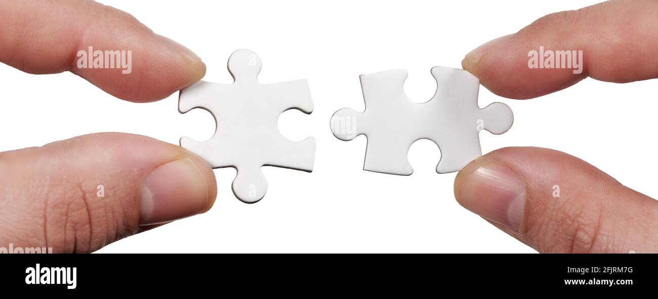 Close up Connection. Hands trying to fit two puzzle pieces together