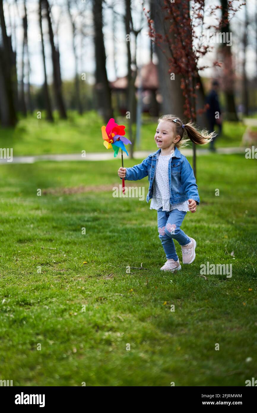 Little girl playing with a pinwheel outdoor in the park Stock Photo - Alamy