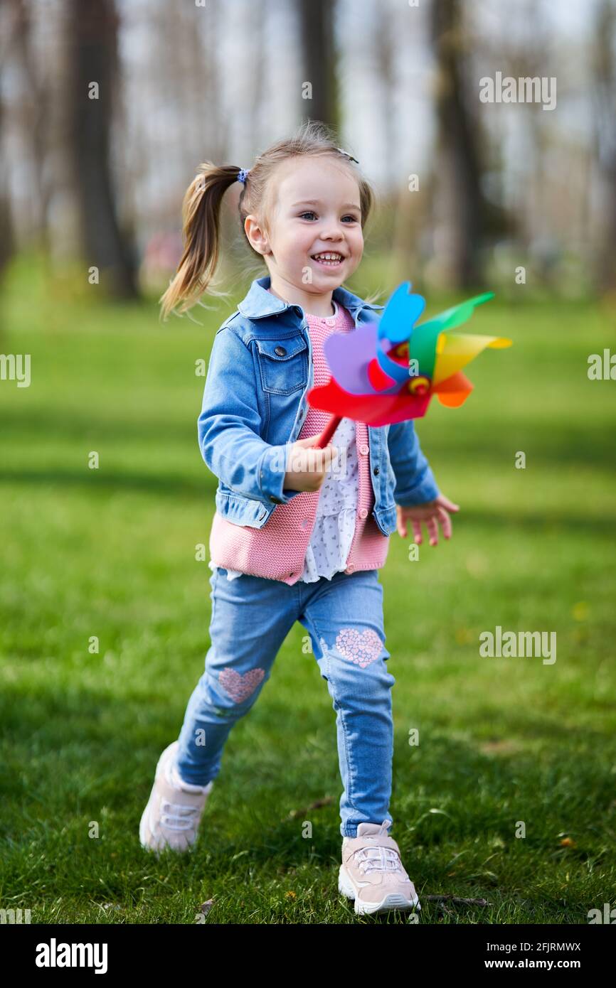 Little girl playing with a pinwheel outdoor in the park Stock Photo - Alamy