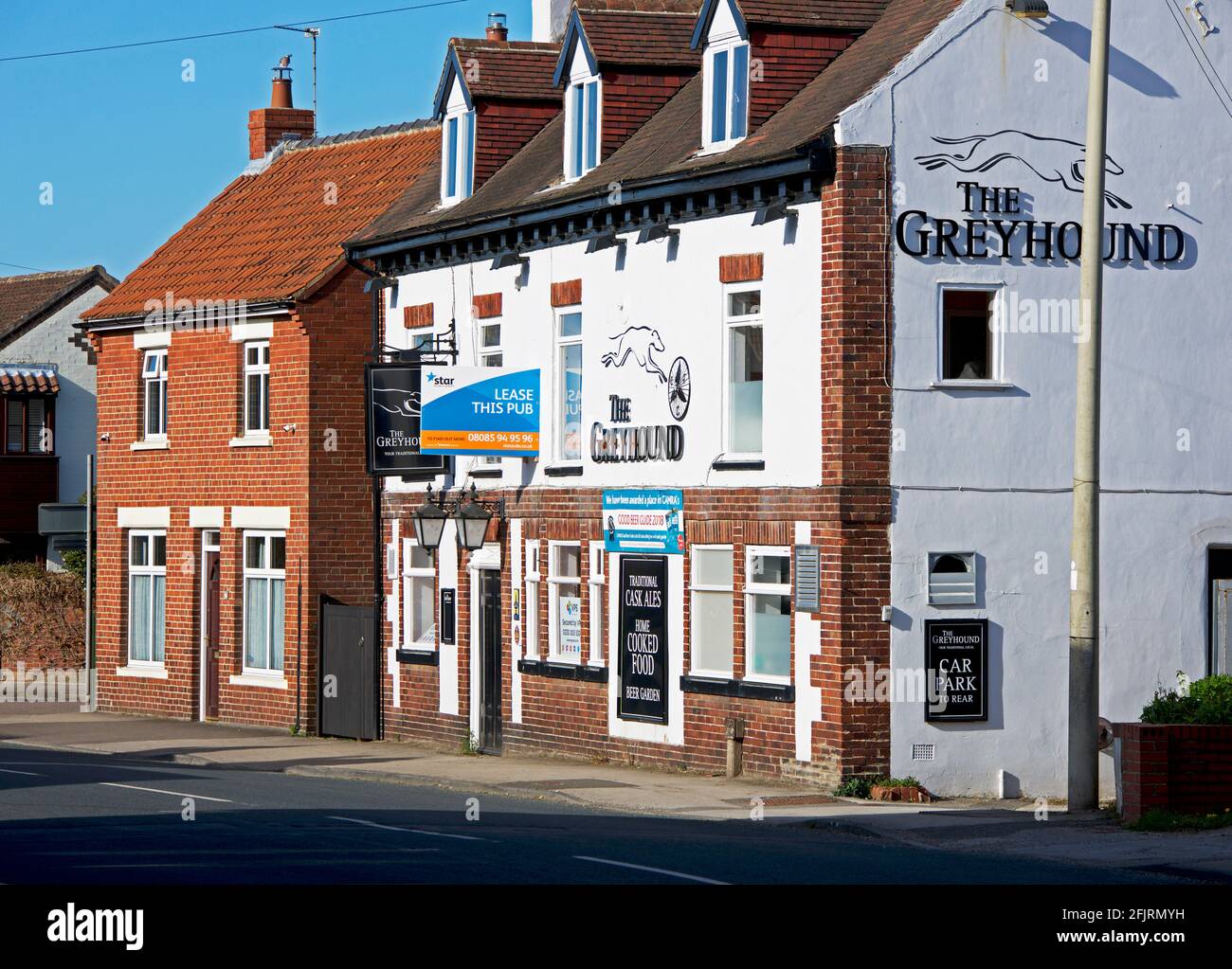 The Greyhound pub, in the village of Riccall, with a sign - Lease this pub - North Yorkshire, England UK Stock Photo