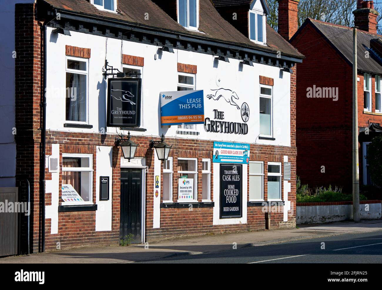 The Greyhound pub, in the village of Riccall, with a sign - Lease this pub - North Yorkshire, England UK Stock Photo