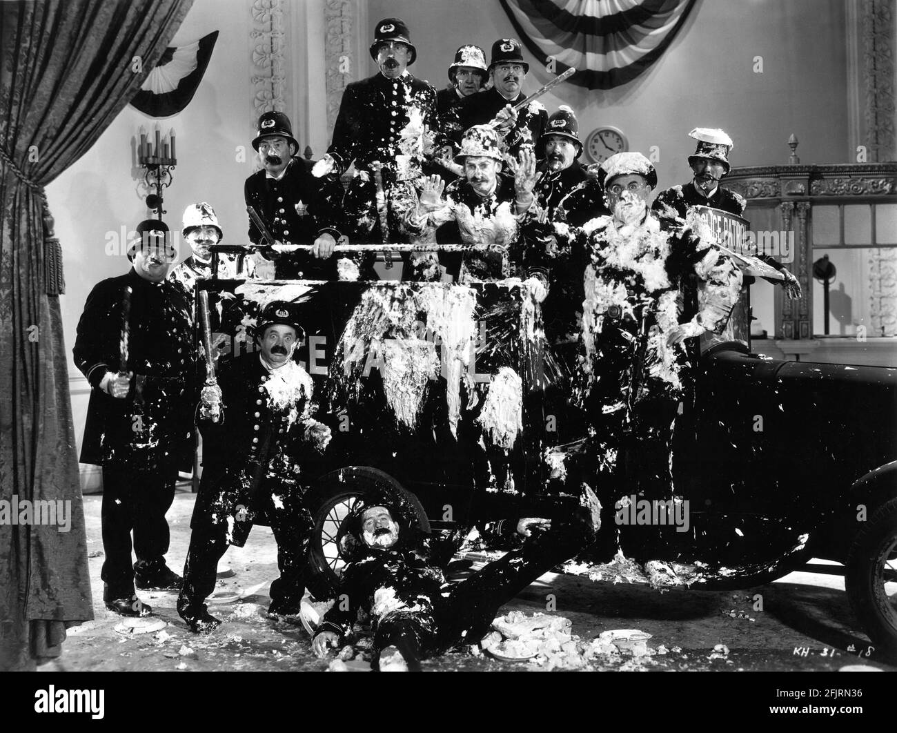 KEYSTONE KOPS including FORD STERLING and BOBBY DUNN on set candid portrait covered in Custard Pies taken during filming of the slapstick comedy short KEYSTONE HOTEL 1935 director RALPH STAUB story and screenplay Joe Traub The Vitaphone Corporation / Warner Bros. Stock Photo