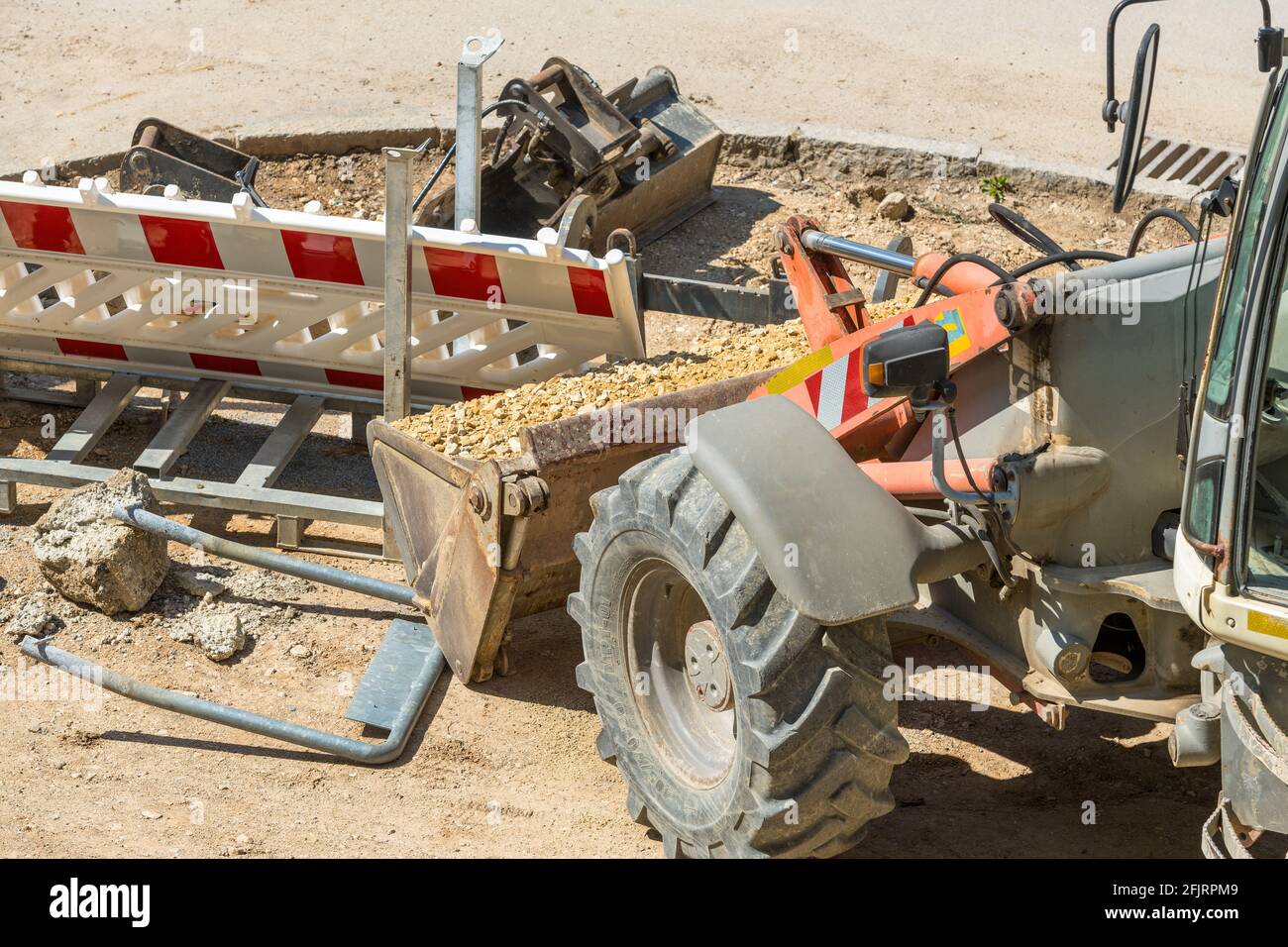 Road construction site with excavator and sand, road construction work in progress Stock Photo
