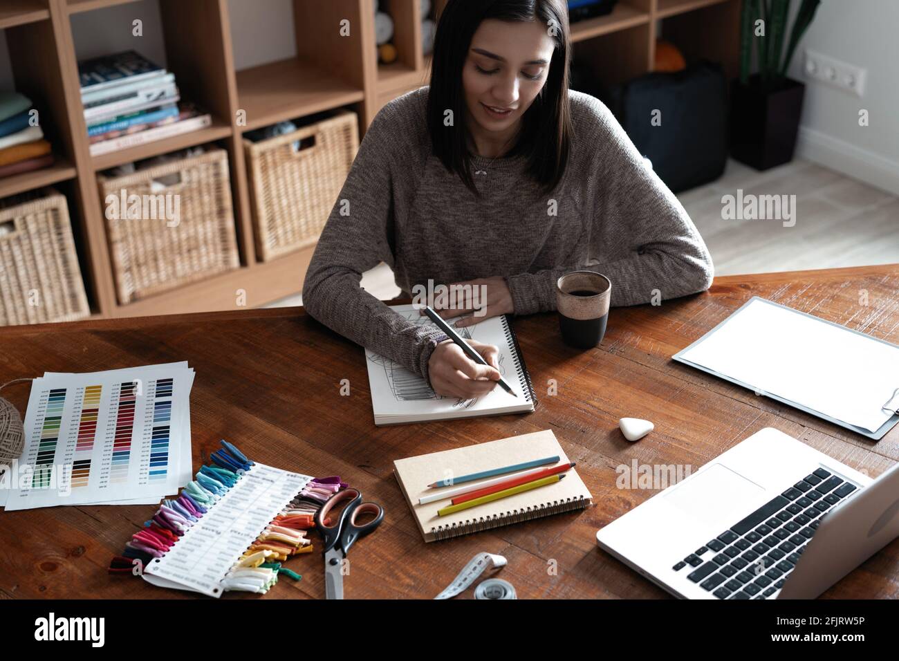 Indian mixed-race pretty designer working at her desk in her office. Stock Photo