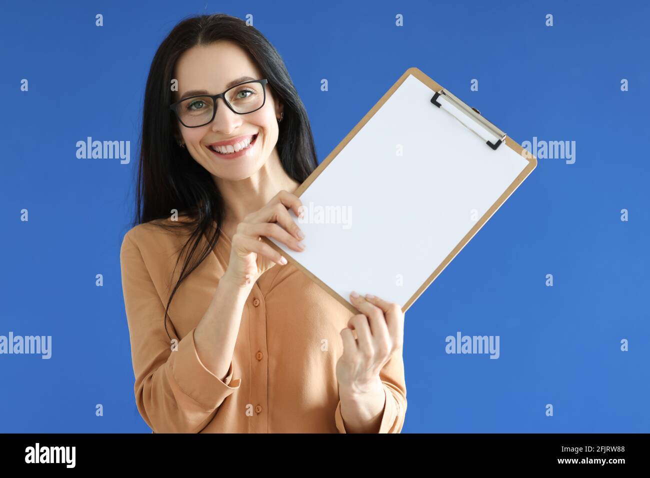Woman with glasses holding blank sheet of paper in her hands Stock ...